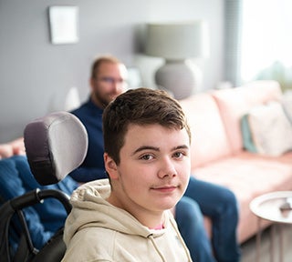 Boy in light colored hooded sweatshirt looking to his right